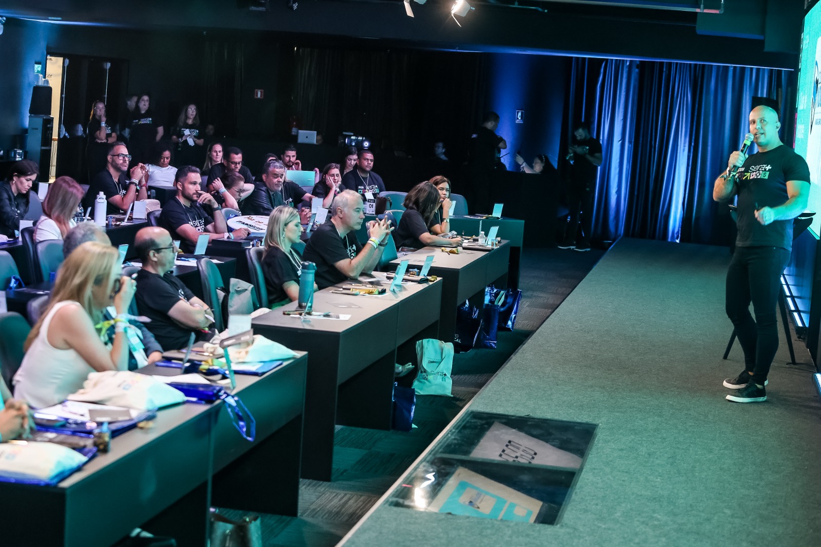 Auditório lotado com palestrante ao fundo durante evento do setor pet